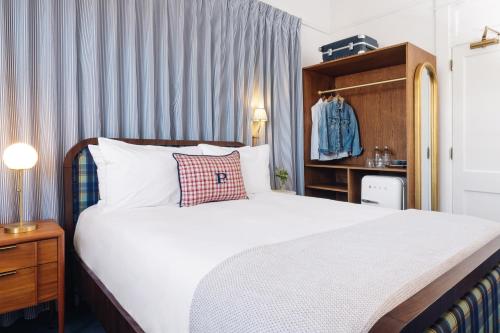 a bedroom with a large white bed and a cabinet at Palihotel San Diego Gaslamp Quarter in San Diego