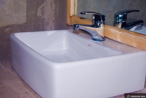 a white sink with a faucet in a bathroom at freedom inn in Arusha