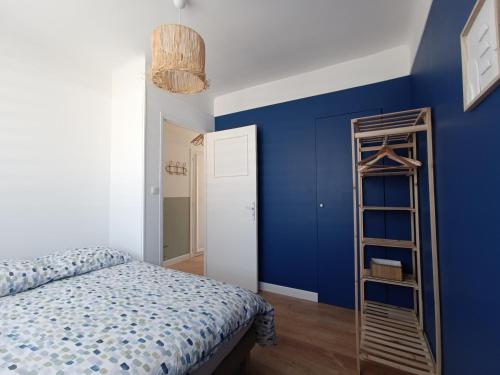 a blue bedroom with a bed and a ladder at chez Clem in Calais
