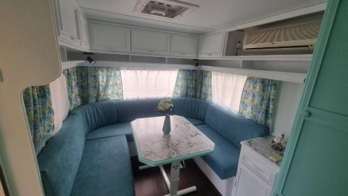 a living room with a blue couch and a table at Каравана Тиана in Sozopol