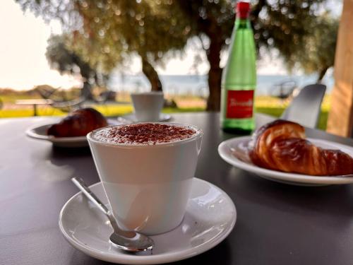 a cup of coffee on a table with croissants at Le Lenze Don Mimì Glamping in Mattinata