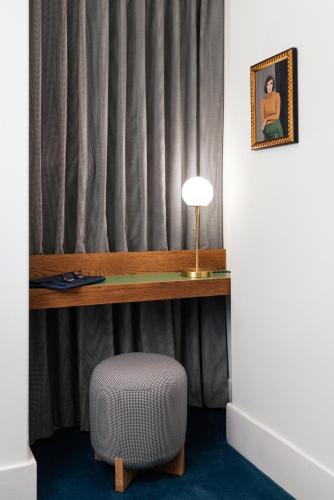 a desk and a chair in a room with a lamp at Palihotel San Diego Gaslamp Quarter in San Diego