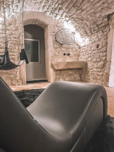 una sala de estar con un banco en una pared de piedra en Le Pandore, en Junas