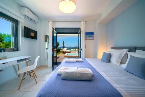 a bedroom with a blue bed with a desk and a window at Mythic Olive villa - Heated Pool - Amazing view in Perivólia
