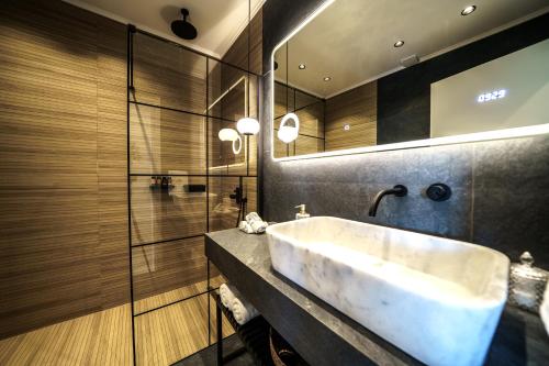 La salle de bains est pourvue d'un lavabo blanc et d'une douche. dans l'établissement Mythic Olive villa - Heated Pool - Amazing view, à Perivólia