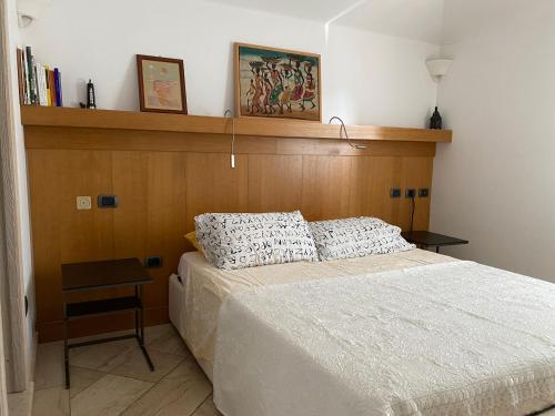 a bedroom with a bed with a wooden headboard at La casa degli Ibiscus in Porto Ottiolu