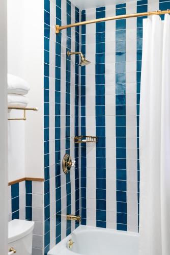a bathroom with a blue and white striped shower curtain at Palihotel San Diego Gaslamp Quarter in San Diego