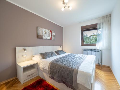 a bedroom with a large bed and a window at Apartments Zlatko & Mira Dorcic in Baška