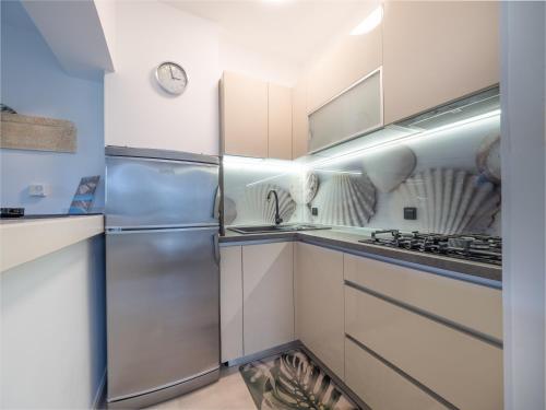 a kitchen with white cabinets and a stainless steel refrigerator at Apartments Zlatko & Mira Dorcic in Baška