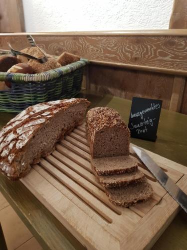 a cutting board with a loaf of bread and a knife at Berg-Gasthof Hötzelein in Kunreuth