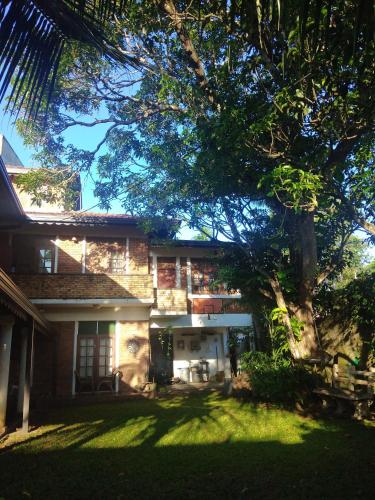 uma casa com uma árvore em frente em Roche's Cozy Corner R-1 Upper Level em Madiwala