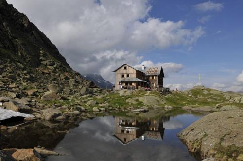 a house sitting on top of a hill next to a lake at Haus Elisabeth in Neustift im Stubaital