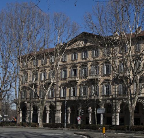 un grand bâtiment en pierre avec des arbres devant lui dans l'établissement LAVI' 82 Apartament, à Turin