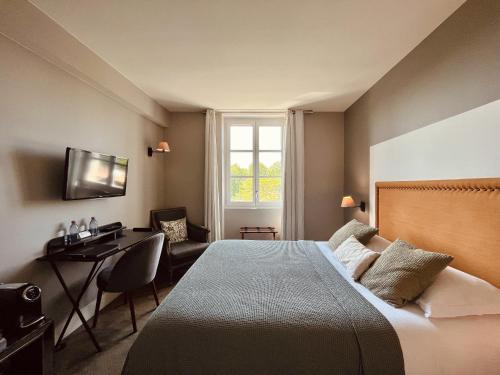- une chambre avec un lit, un bureau et une fenêtre dans l'établissement Hôtel des Basses Pyrénées - Bayonne, à Bayonne