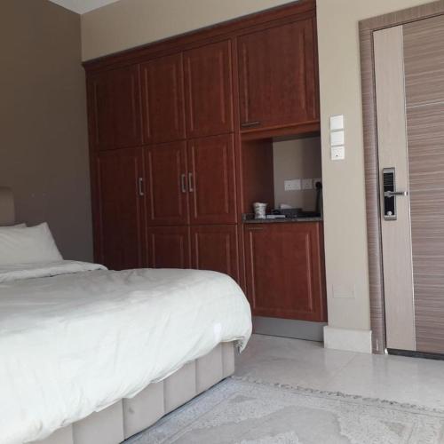 a bedroom with a bed and wooden cabinets at Blue Revan chalet in Salalah