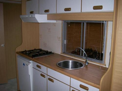 a small kitchen with a sink and a stove at Camping domki letniskowe in Warsaw