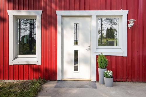 a red house with a white door and two windows at Albatross 