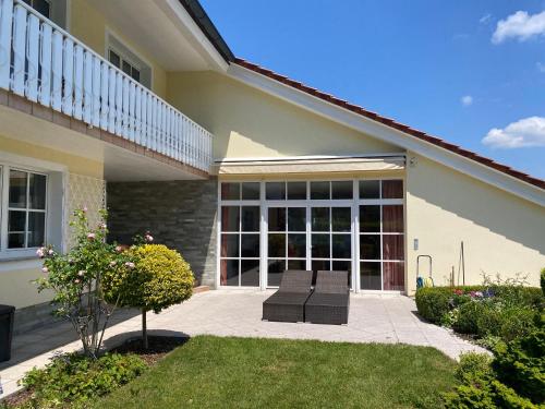 a patio with two chairs in front of a house at Luxury-Suites Traunsee in Traunkirchen