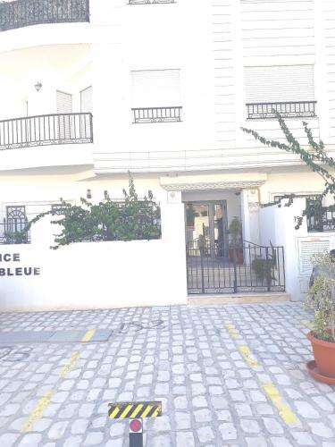 a white building with a door and some plants at La perle bleue in La Goulette