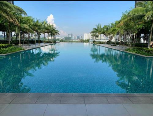 a large pool of blue water with palm trees at Revo Home by AK Group in Cyberjaya