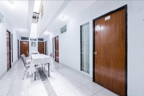 uma sala de jantar com uma mesa e uma porta de madeira em Hotel Cemara Gading em Bubulak 3