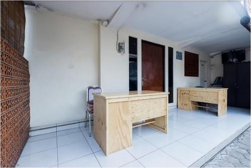 a room with two wooden desks in a room at Hotel Cemara Gading in Bubulak 3