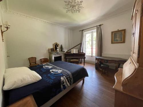 - une chambre avec un lit et un piano dans l'établissement Lovely family home in Chartreuse mountains, à Voreppe