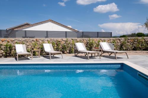 un grupo de sillas y una piscina en Holiday house JEWEL with private pool, en Kornić