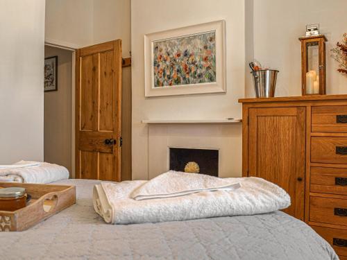 a bedroom with two beds and a fireplace at Chapel House in Bourton on the Water