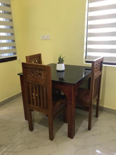a dining room table with two chairs and a plant on it at Gods own home stay in Cochin