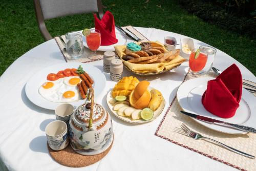 a white table topped with plates of breakfast food at Kandy Tree Tops in Kandy