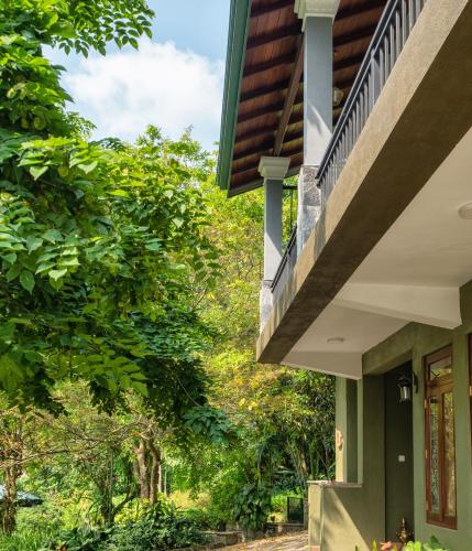 a house with a balcony and trees in the background at Kandy Tree Tops in Kandy