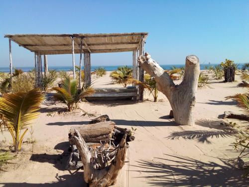 a wooden shelter on a sandy beach with the ocean at Cytyz Appart Hôtel in Mahajanga