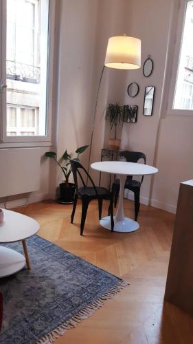 un salon avec deux tables et une lampe dans l'établissement Au cœur du quartier Latin, à Paris