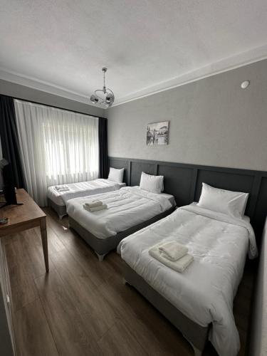 una camera d'albergo con due letti e un tavolo di DERİN BUTİK HOTEL a Tekirdağ