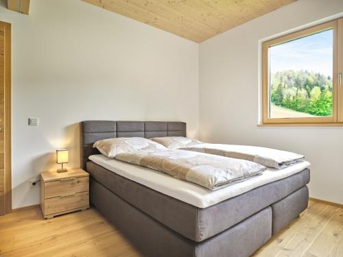 Un dormitorio con una cama grande y una ventana en PureEscape en Faistenau