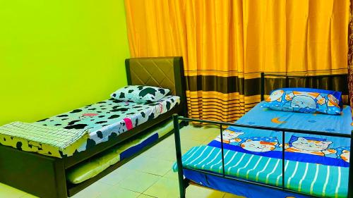 two twin beds in a room with green walls at Am Homestay Rembau in Rembau