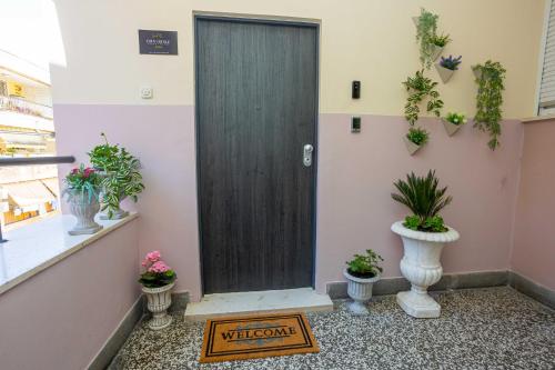 a welcome sign in front of a door with potted plants at City and Style Luxury Rooms Split in Split