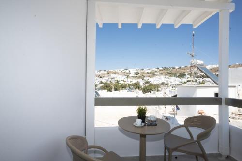 a room with a balcony with a table and chairs at Salvatore's Island House in Mikonos