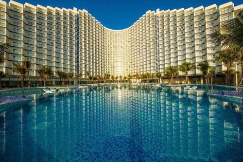 uma grande piscina em frente a um grande edifício em Arena Cam Ranh seaview resort near the Airport em Cam Ranh