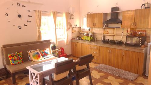 a kitchen with a table and some chairs in a room at Infinity Hill Village Mukteshwar in Mukteswar