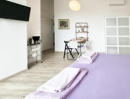 a bedroom with a purple bed and a table at Eleonora in Banjole