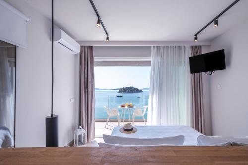a bedroom with a bed and a view of the ocean at Nelly's Apartments in Tolo