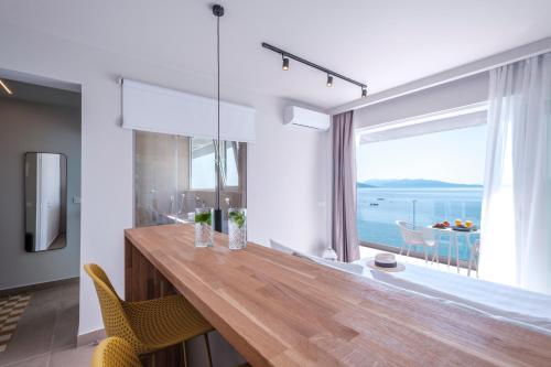 a dining room with a table and a large window at Nelly's Apartments in Tolo
