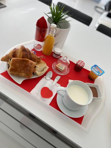 ein Tablett mit einer Tasse Kaffee und einem Teller Essen in der Unterkunft Love room avec spa privatif in Le Rove
