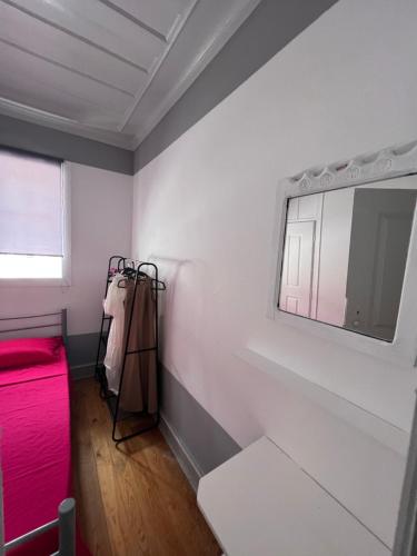 Habitación con cama roja y ventana en Casa Flamingo, en Figueira da Foz