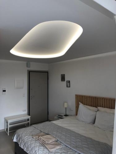 ein Schlafzimmer mit einem großen Bett mit einem großen Licht an der Decke in der Unterkunft Serafina suite byArtistUnknown in Vari