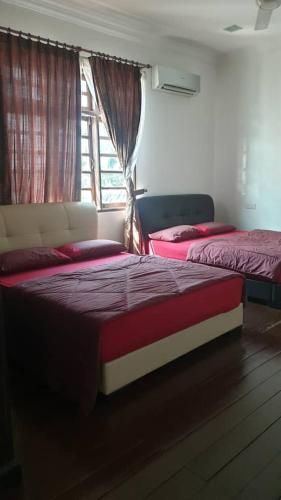 two beds in a room with a window at DamaiSari Tawang in Bachok