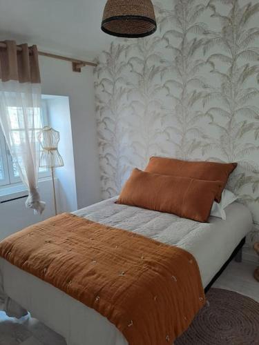 Maison dépaysante au calme Soyaux Angoulême في Soyaux: غرفة نوم مع سرير وبطانية بنية اللون