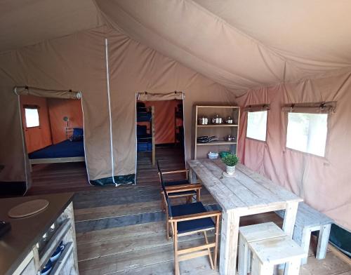 ein Zelt mit einem Tisch und Stühlen in der Unterkunft Le Lodge de la Chouette in Quarré-les-Tombes